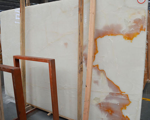 Golden brown wavy grain white onyx slab